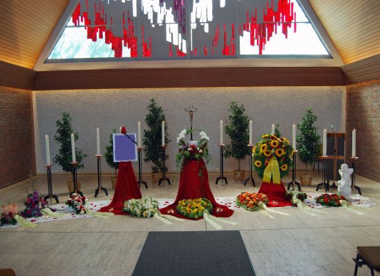 Trauerhalle mit Sarg, rotem Tuch und Sonnenblumen