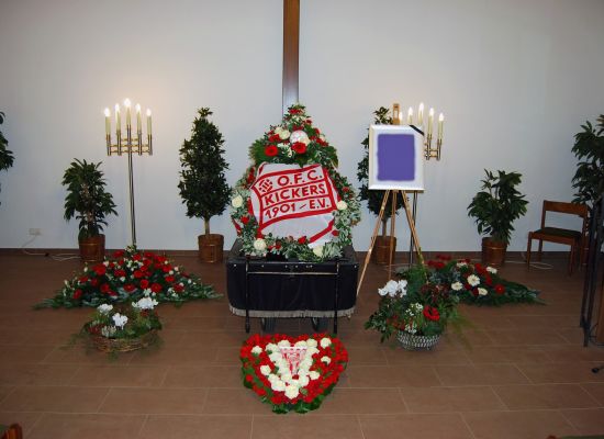 Trauerhalle mit Sarg, Blumenschmuck und einem Vereinskranz